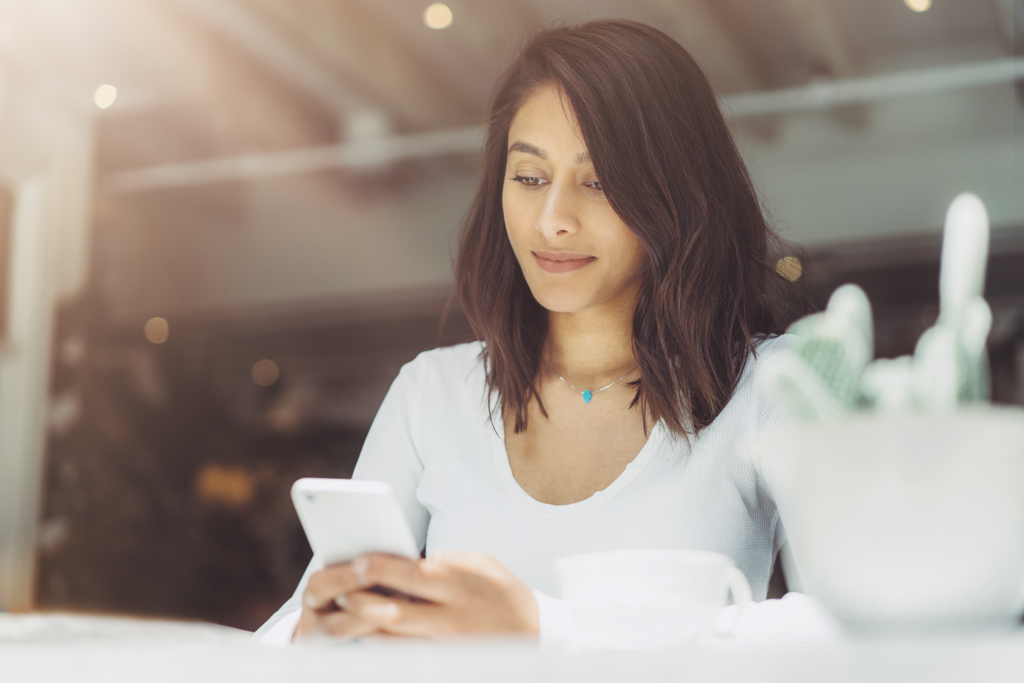 newsletter-dqs-woman looks at her smartphone