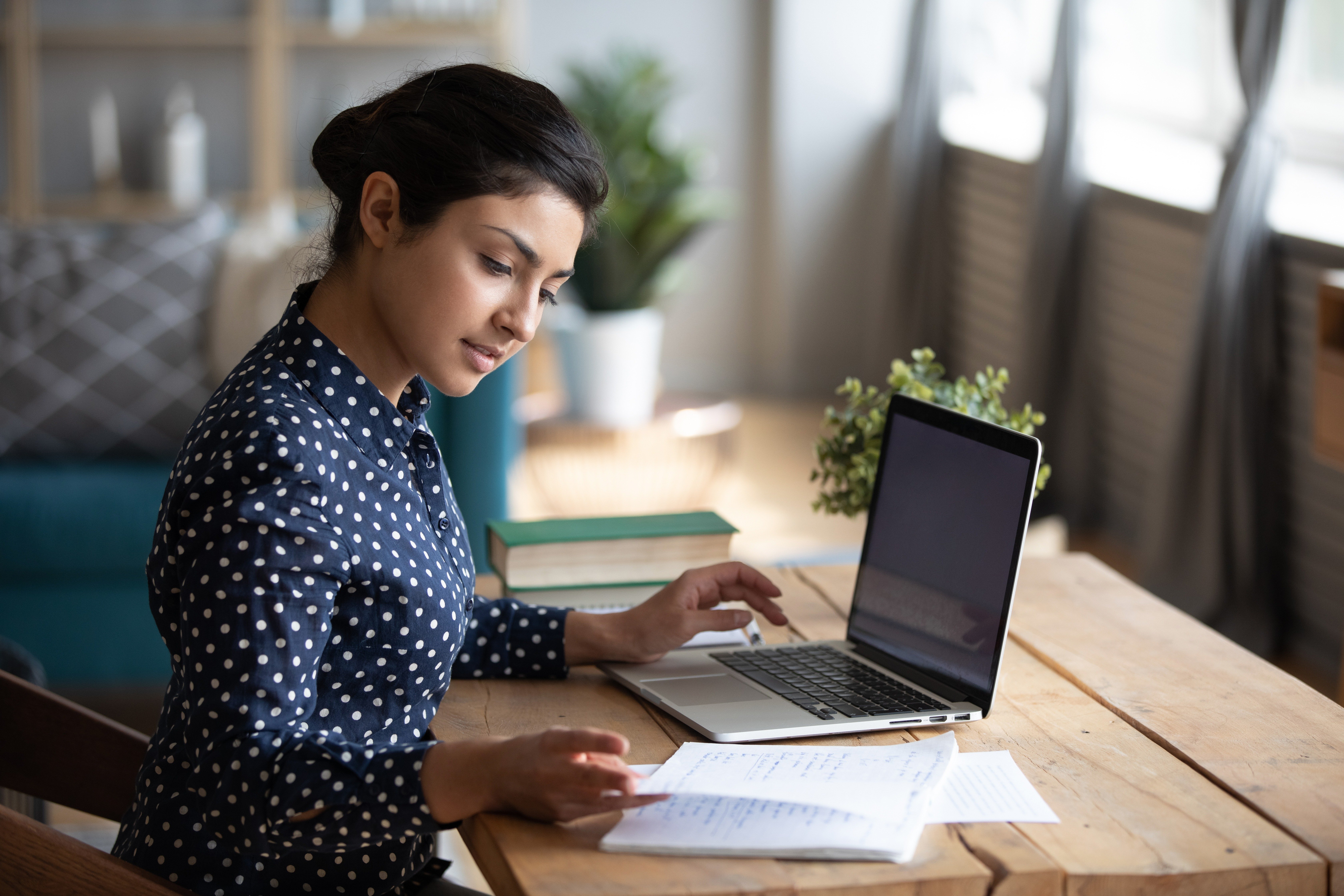 qualitaet-about-dqs-eine geschaeftsfrau liest und arbeitet am laptop