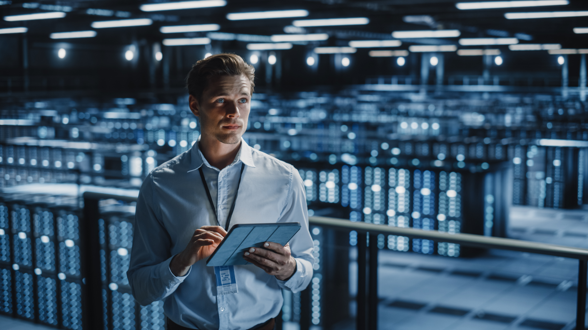 Portrait of Smiling IT Specialist Using Tablet Computer in Data Center. Big Server Farm Cloud Comput