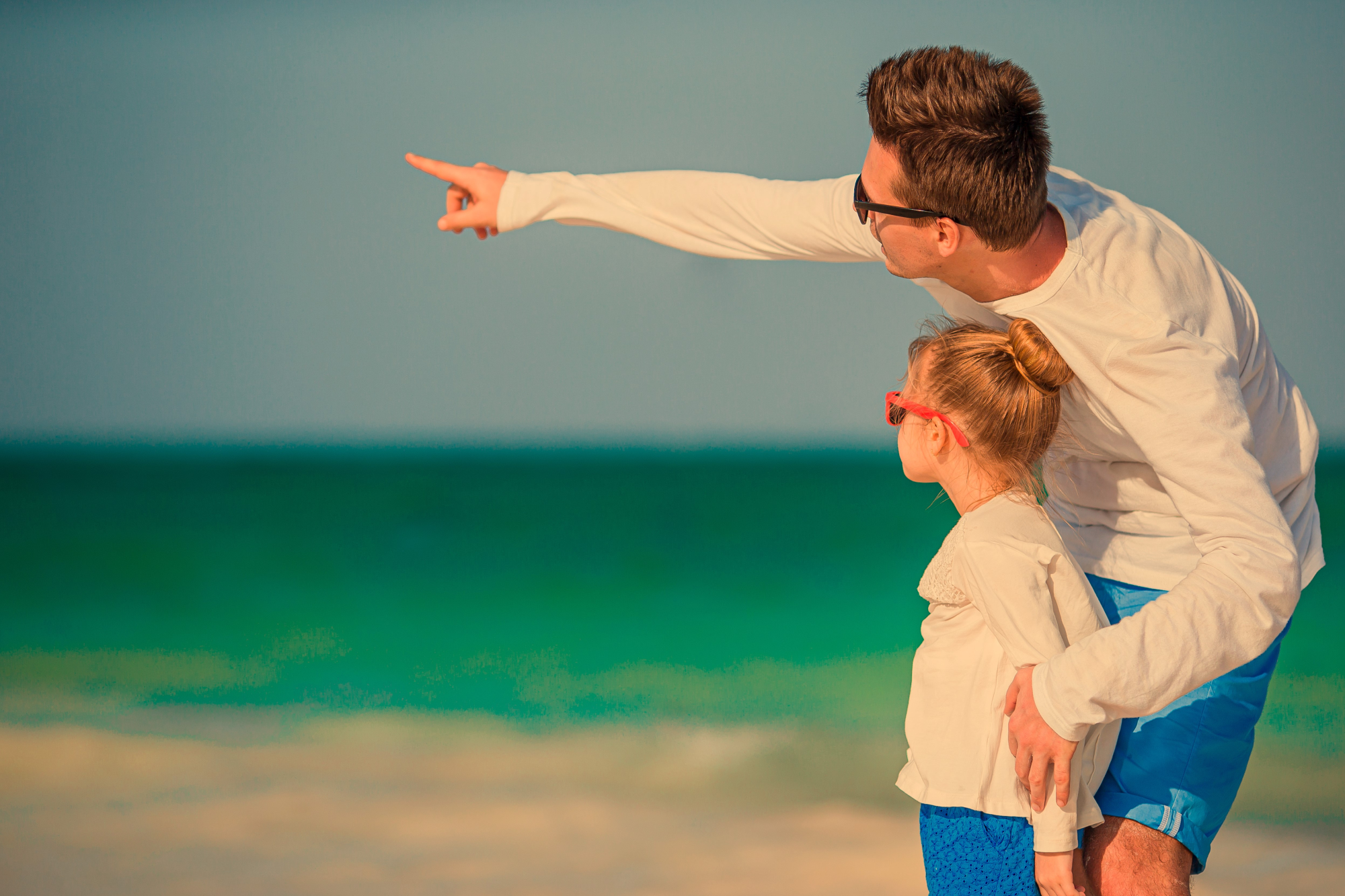 Little girl with her father running on the beach