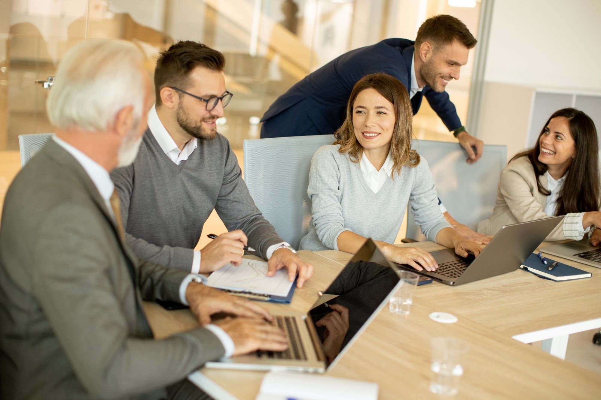 Handsome senior businessman working together with young business people in the office