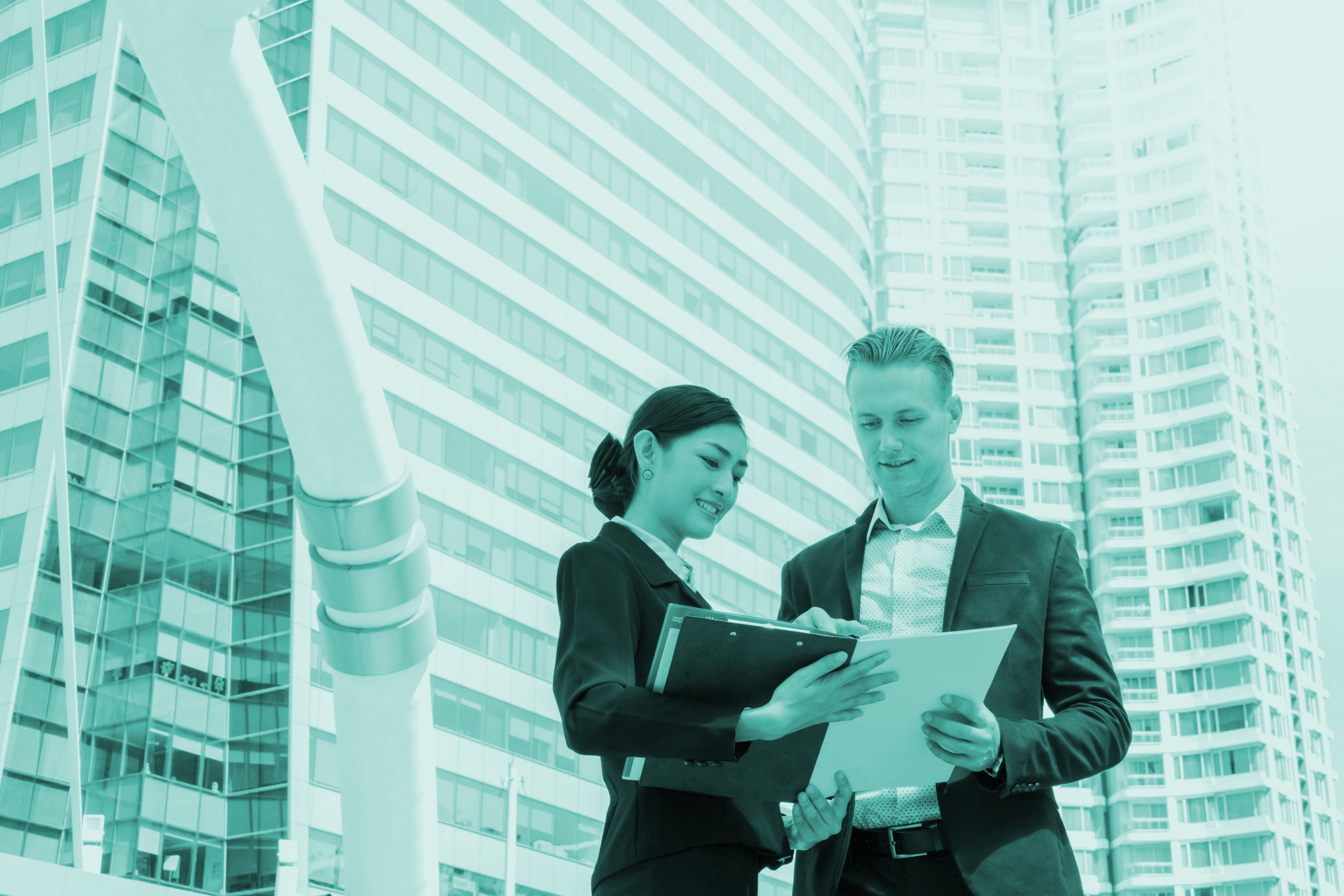 Man and woman talking in front of a skyscraper