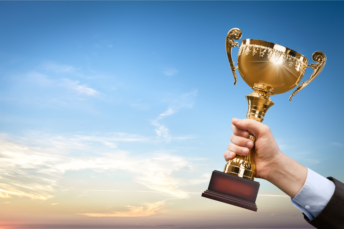 Hands holding golden trophy on background