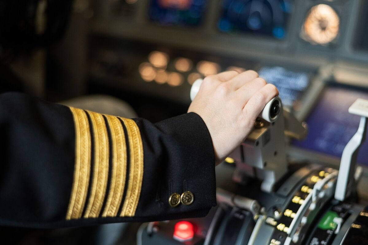 Pilot's hand on the plane engine control stick