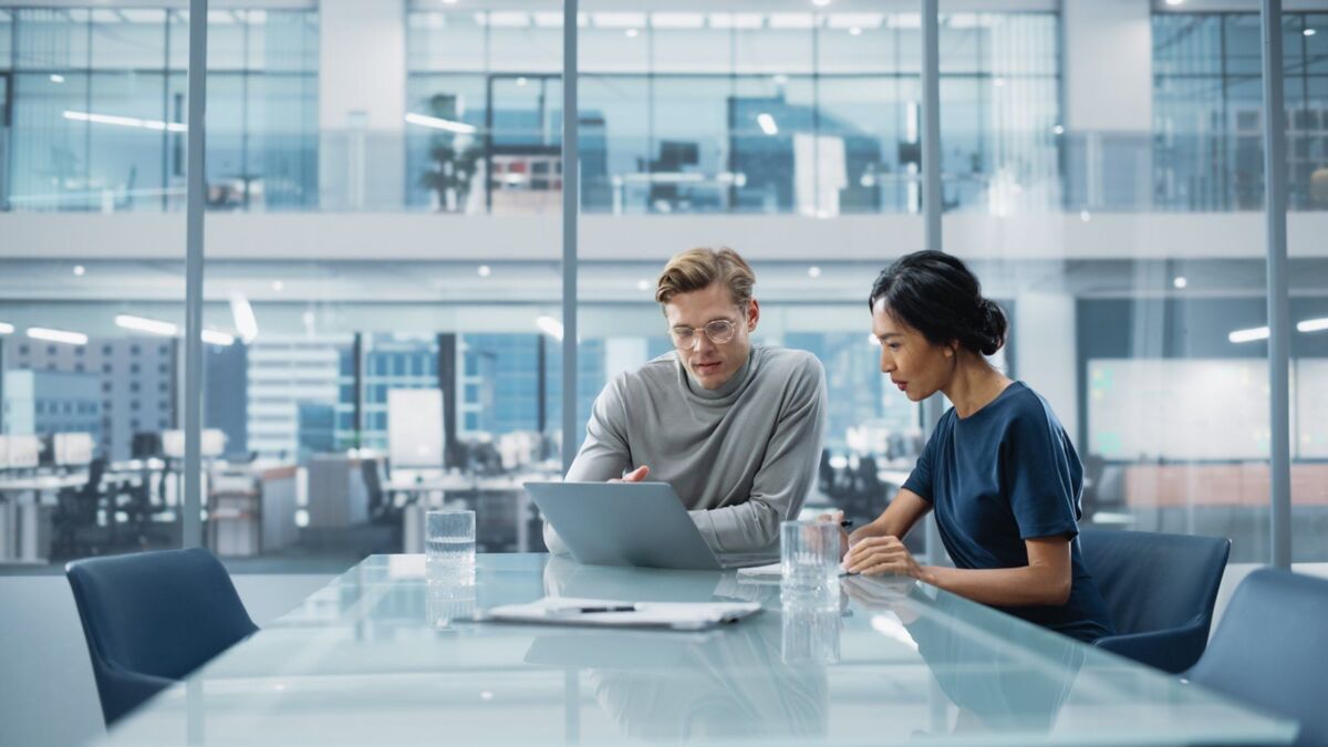 quality-management-system-dqs-two young businessmen in a meeting in a conference room with a lot of 