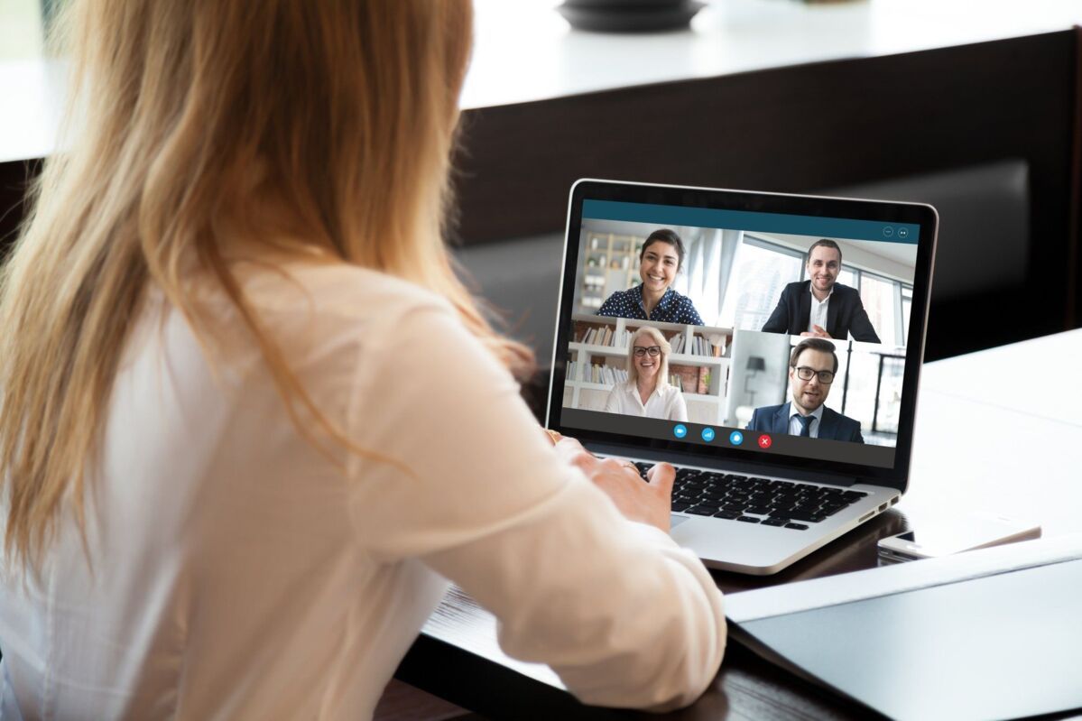online-conference-internal-audits-dqs-a woman sitting at a laptop in a video call with her teammate
