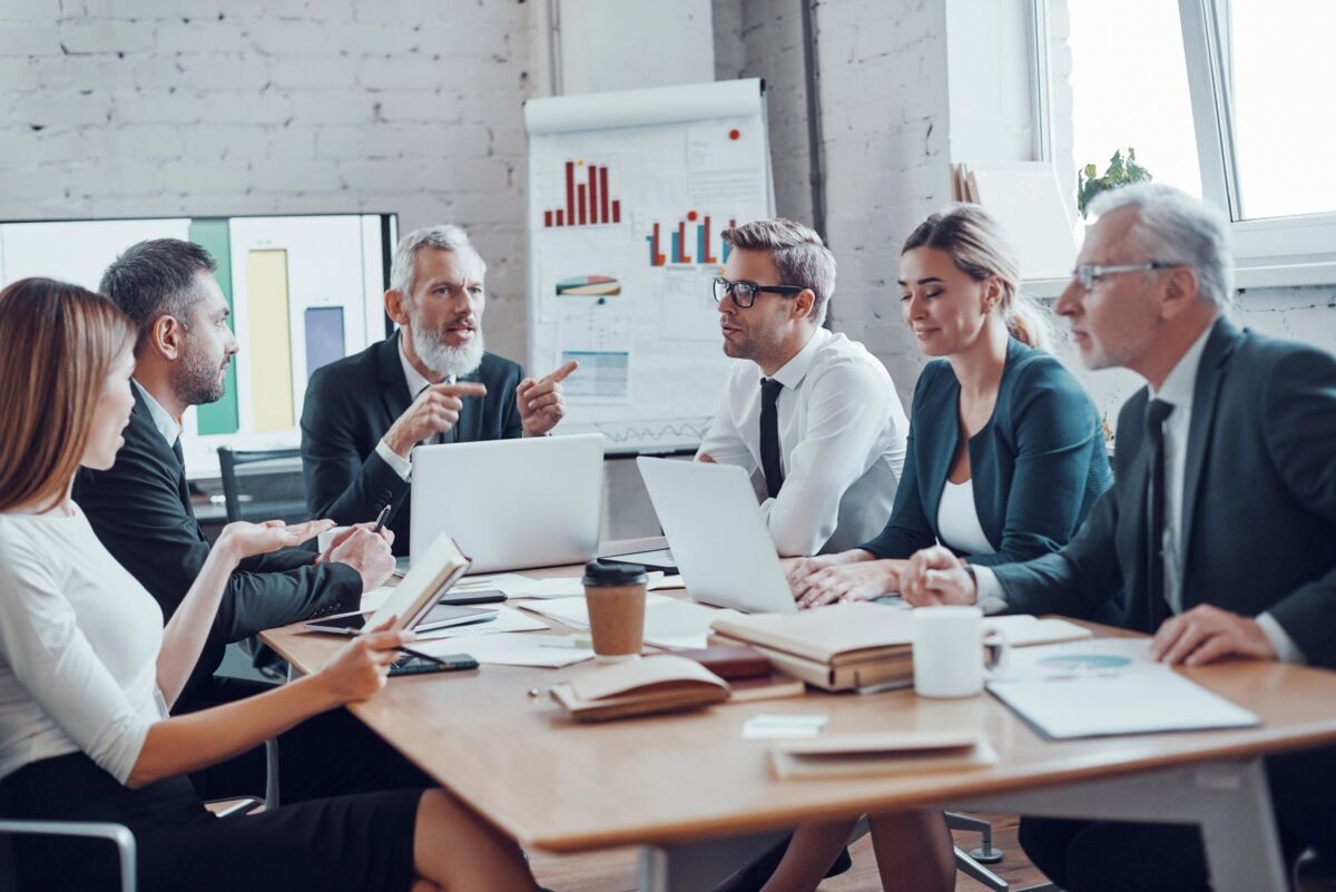 Coworkers discussing new business while working together with colleagues in the modern office