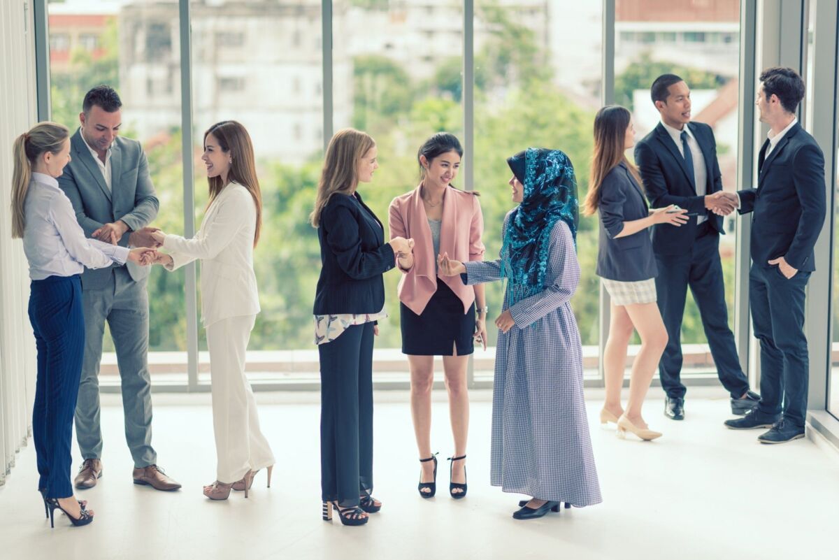 group-learn-dqs-a group of different people talking and shaking hands