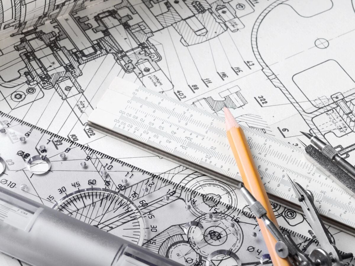 A construction drawing of a technical component; a compass, pencil and logarithm ruler are spread ou