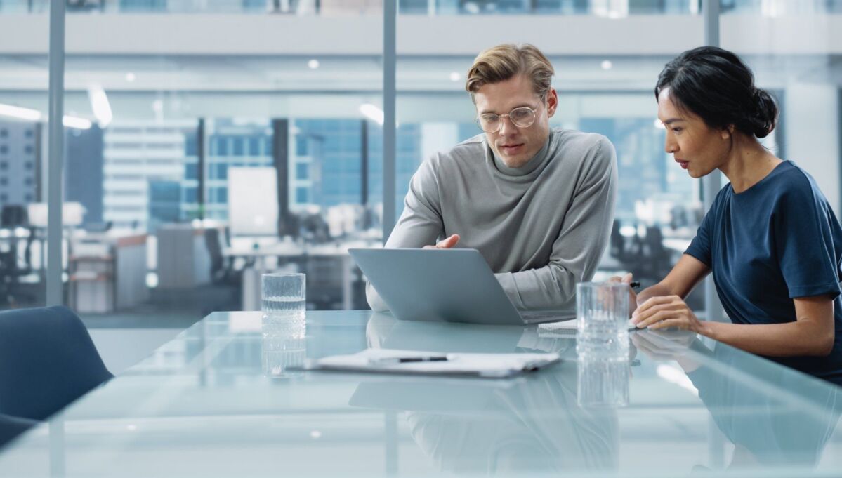 quality-management-system-dqs-two young businessmen in a meeting in a conference room with a lot of 