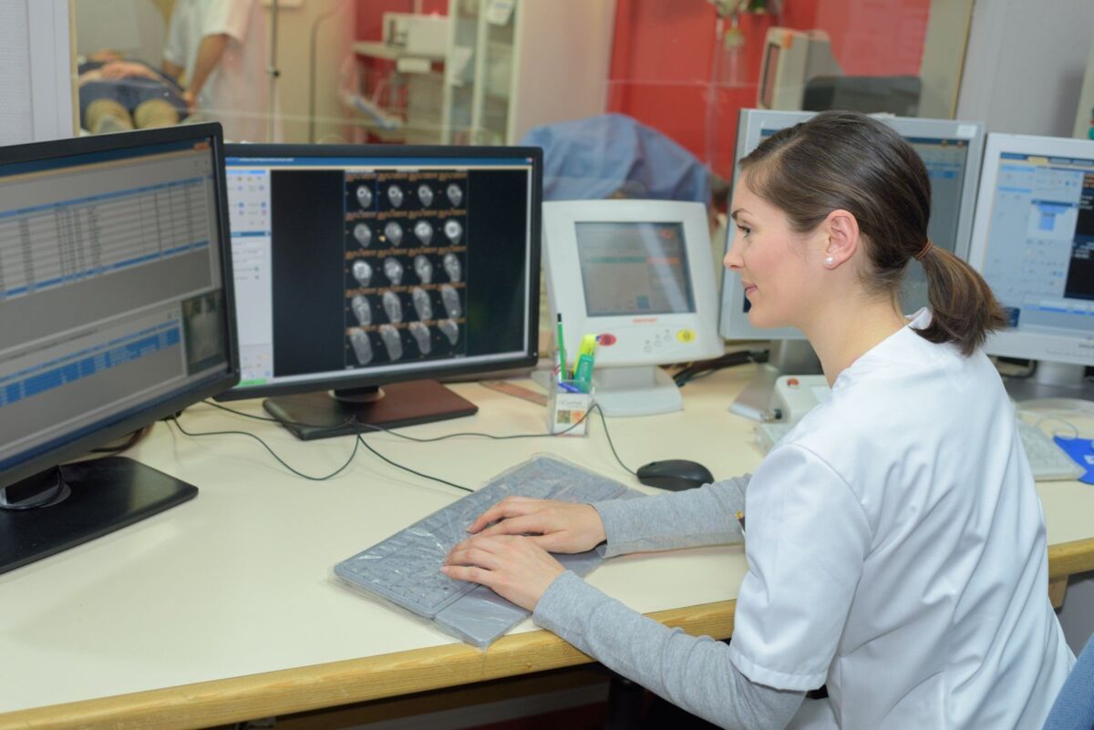 kritis-sector-health-dqs-woman sits at a desk and works on a computer in the health sector