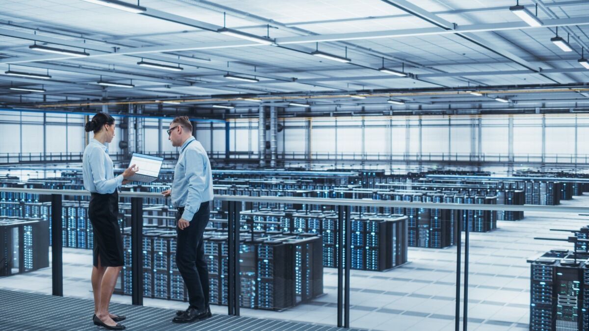 iso-27001-certification-dqs-man and woman with laptop in server room