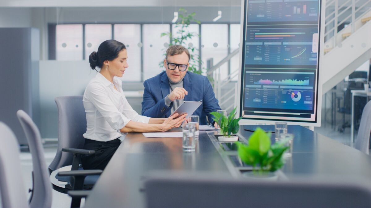 In the meeting room, a businesswoman shows a colleague confidential statistics and business figures 