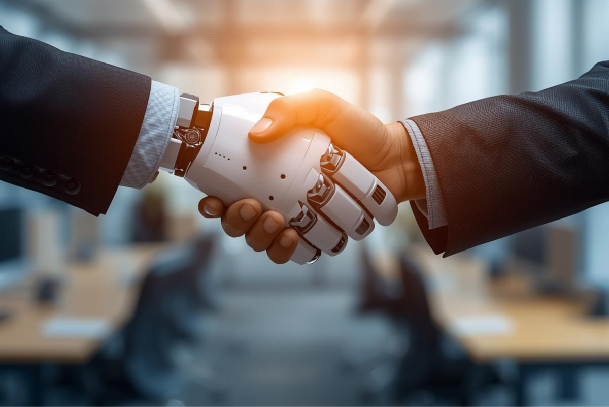 Human handshake with robot hand in a modern office environment, symbolizing collaboration between hu