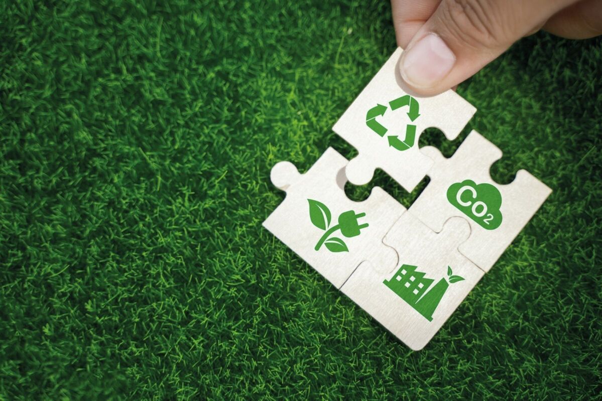 Puzzle showing the pieces that make up a circular economy on green grass backing