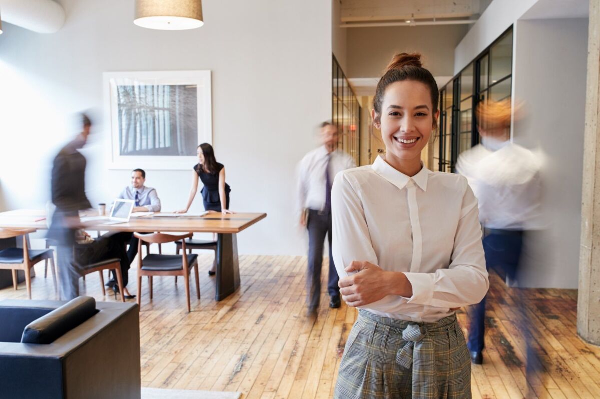 join-dqs-portrait of young woman in a busy modern workplace