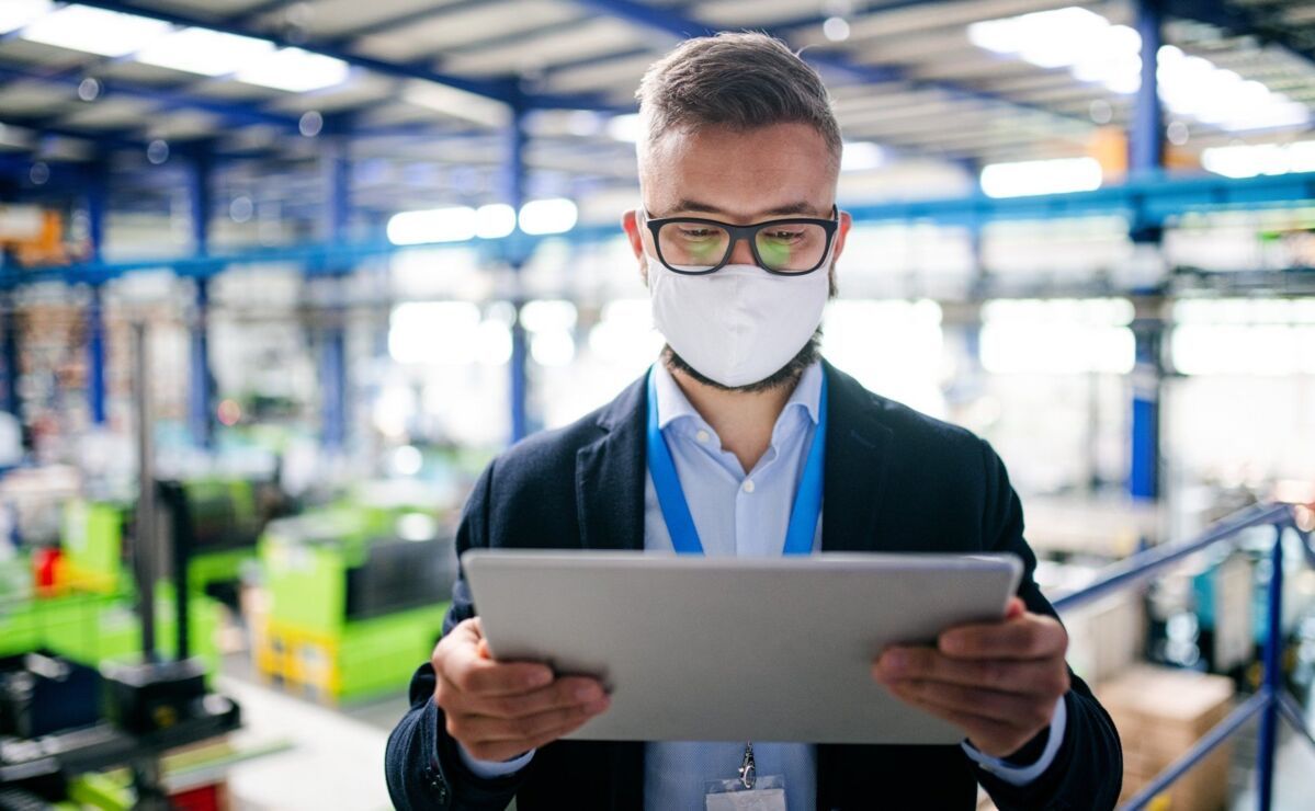 iatf-remote-audit-dqs-man in production hall with tablet