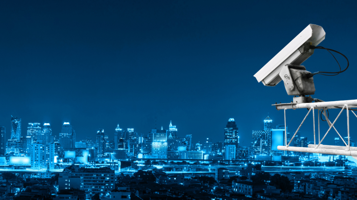 Night skyline with a security camera in the foreground.