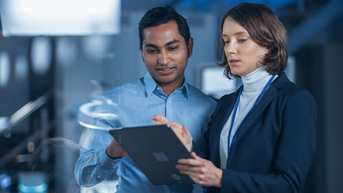 security-about-us-dqs-ein mann und eine frau schauen gemeinsam auf ein tablet