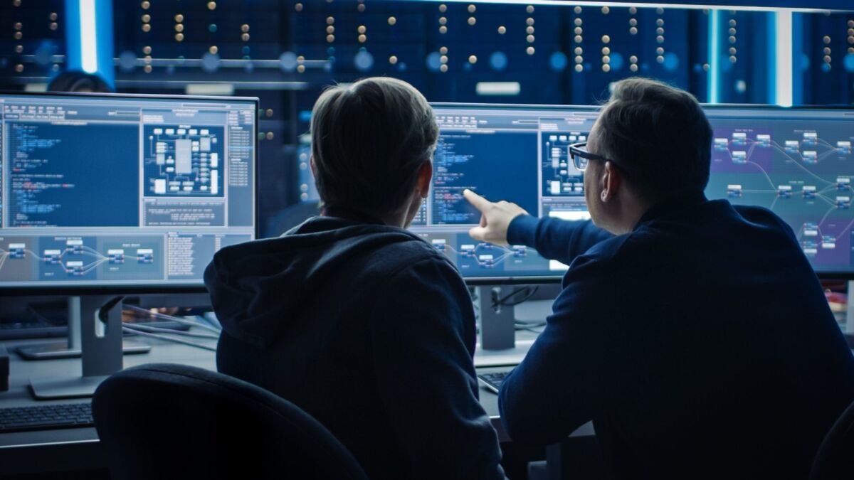 protection-goals-information-security-dqs-two men looking at screens with it information