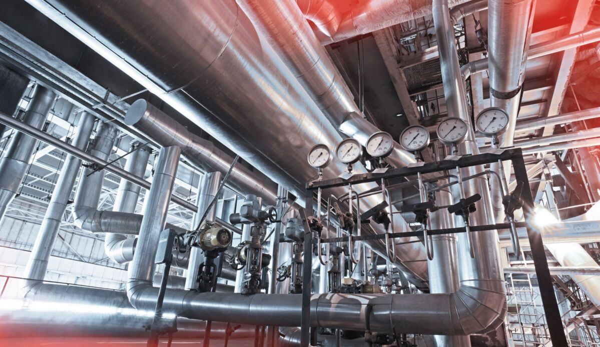 Complex system of nested silver-colored tubes and pipes and gauges for transporting cold and heat in a factory