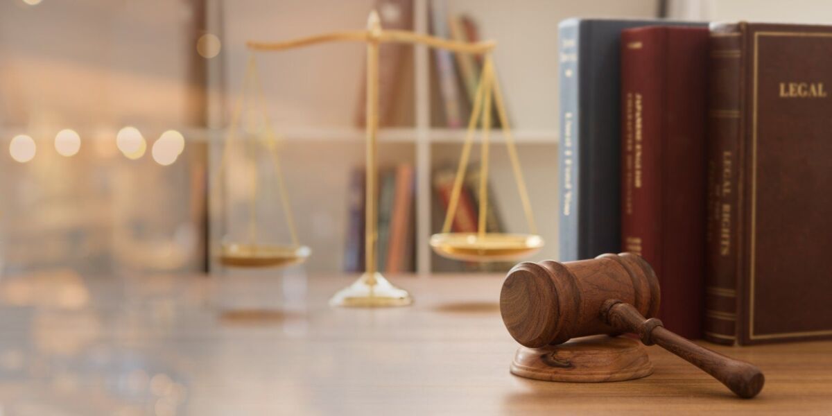 impartiality-about-us-dqs judge's gavel on wooden table with scales and law books in background