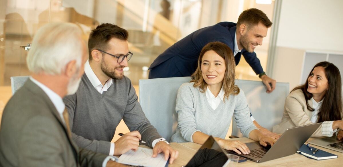 Handsome senior businessman working together with young business people in the office