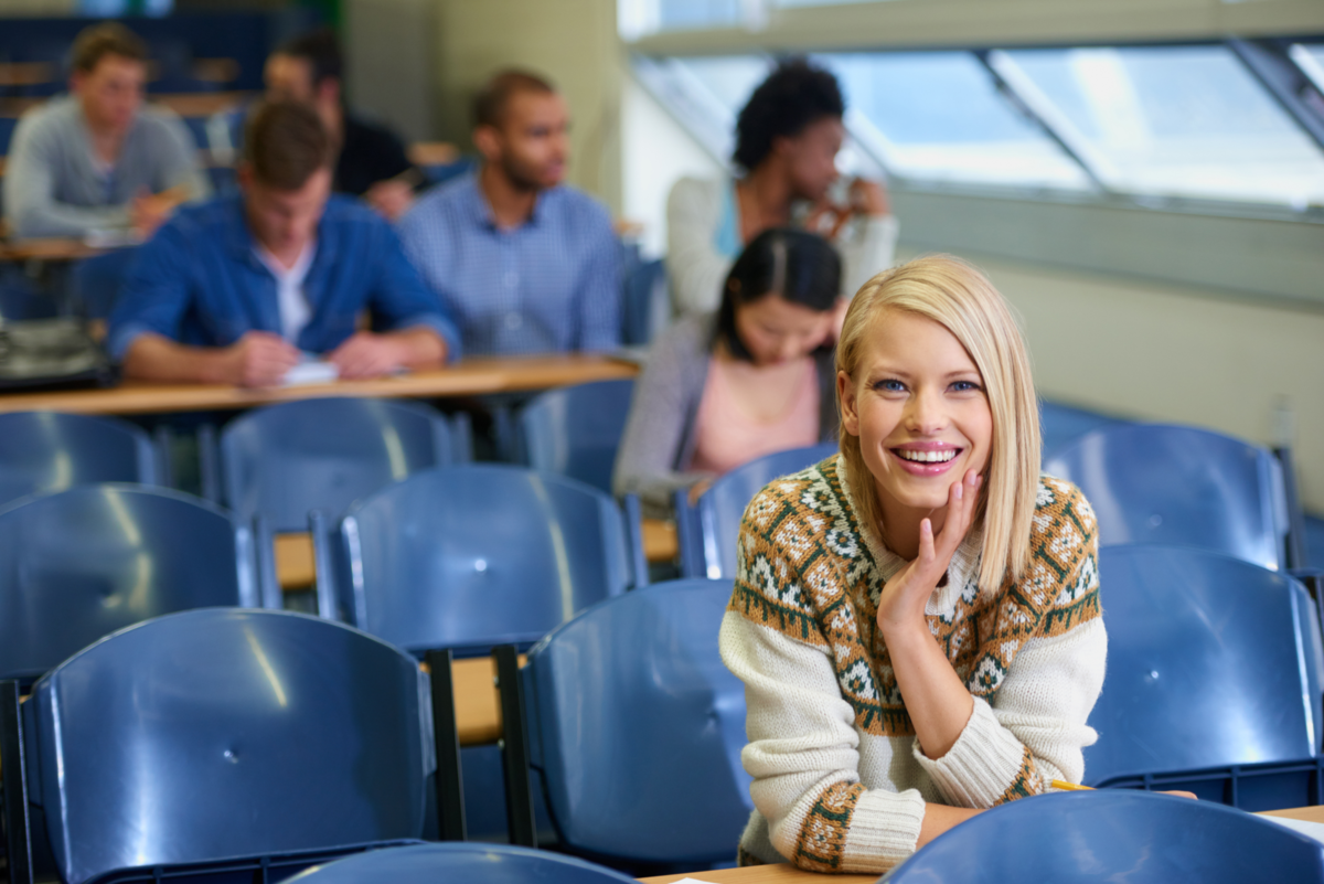 Loving college life. Portrait of a smiling college student sitting in a lecture hall
