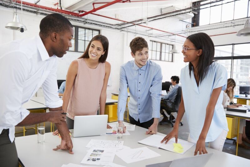 Young business team standing at a desk in open plan office