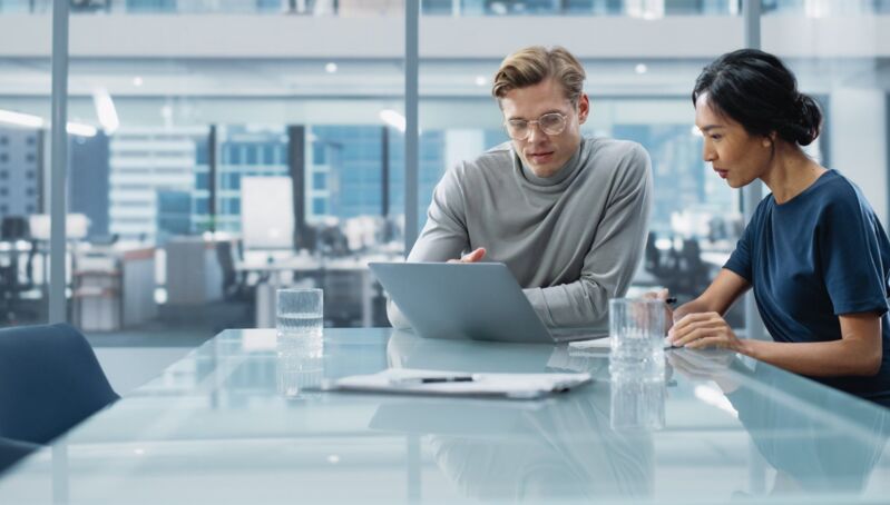 quality-management-system-dqs-two young businessmen in a meeting in a conference room with a lot of 