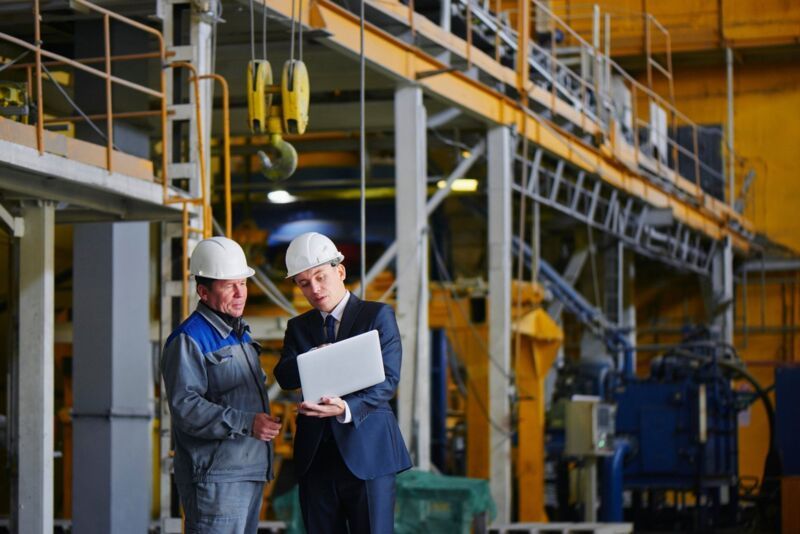iso-45001-certification-dqs-audit discussion between two people in a factory hall