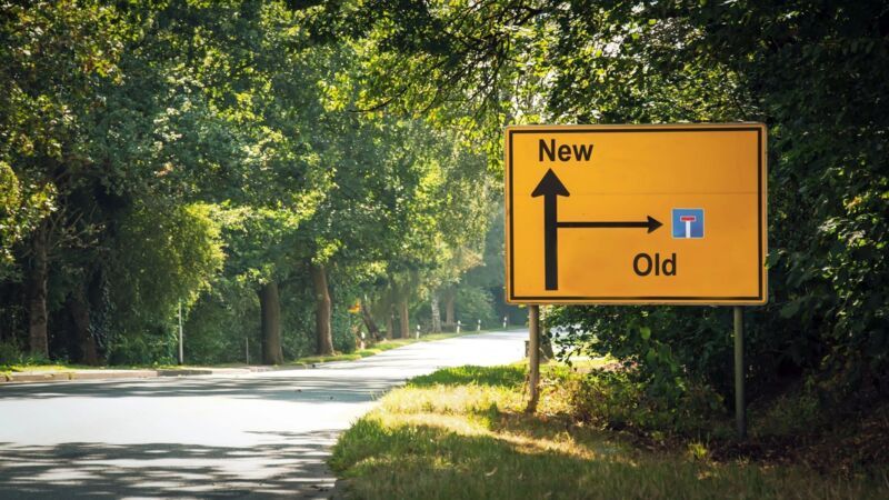 A road sign symbolizes the choice between a new path and an old dead end – an image of change, pro