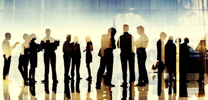Business people standing in a modern building. The image is mirrored and multi-layered. 