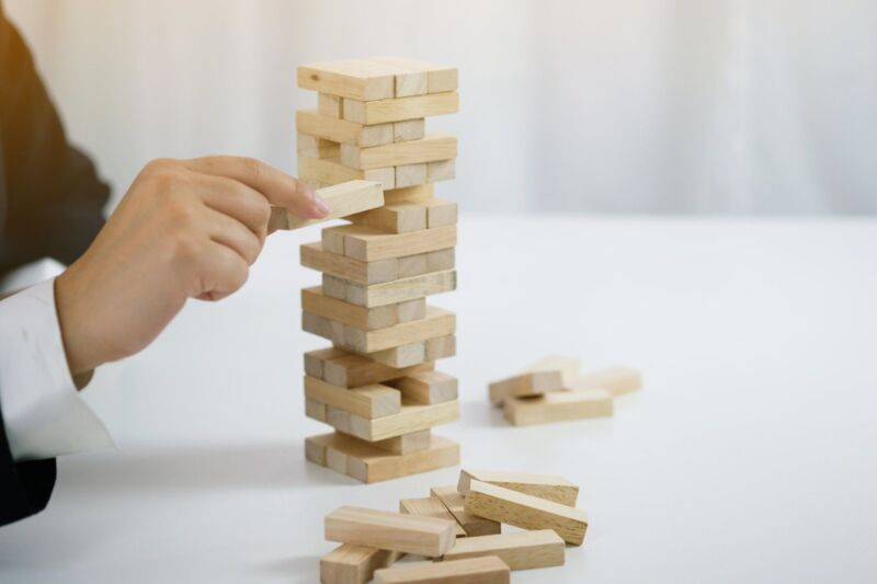 Build a slender tower from small wooden blocks with a lot of care and strategy when placing them cor