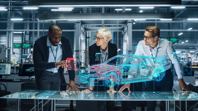 Three engineers working on a virtual 3d model of a car